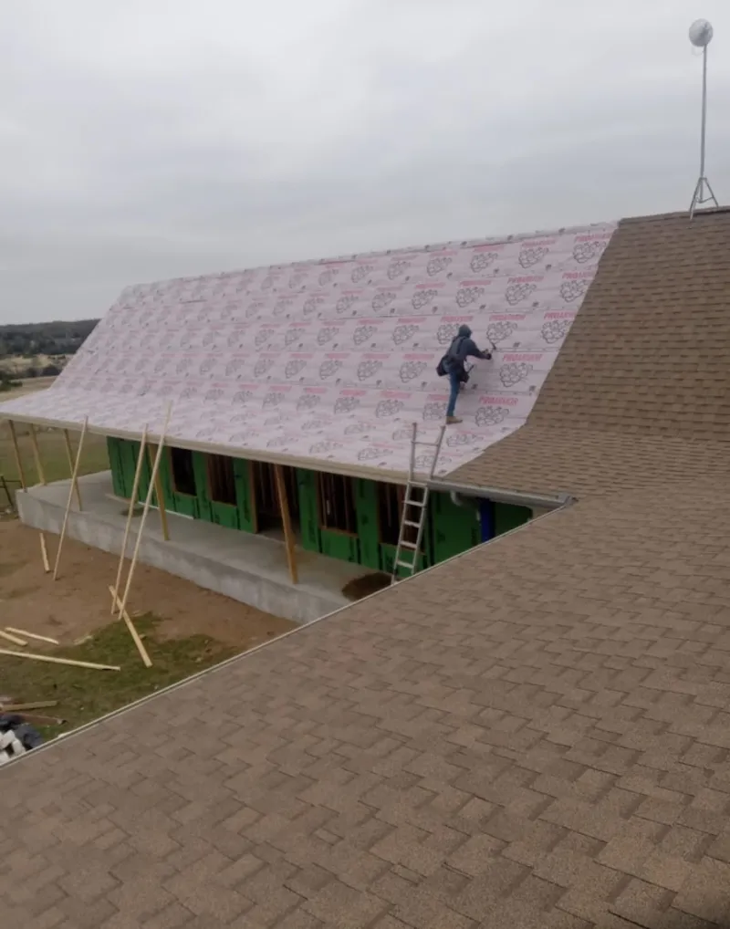 Worker preparing underlayment for a metal roof installation in Sumter